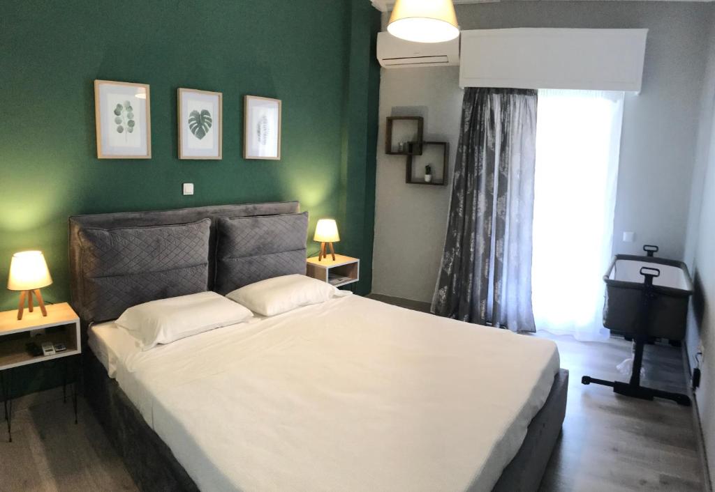 a bedroom with a large white bed with a green wall at Anatoli House in Gaios