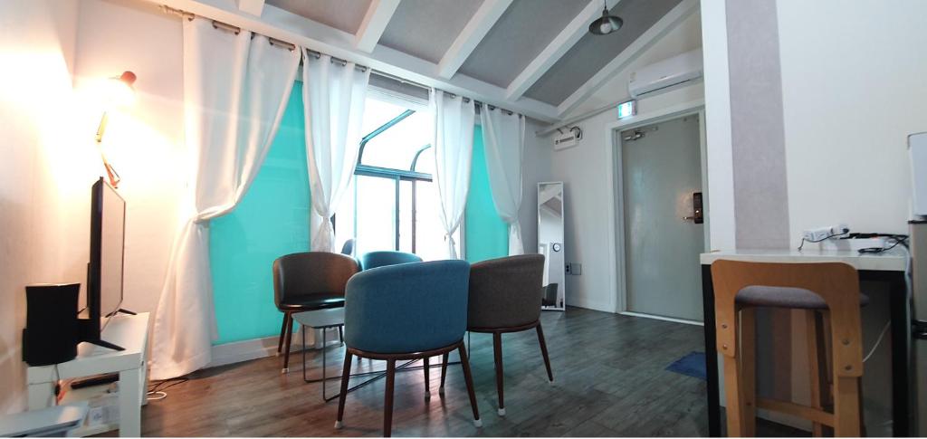 Zimmer mit Stühlen, einem Tisch und einem Fenster in der Unterkunft Comfy & Cozy in Seoul