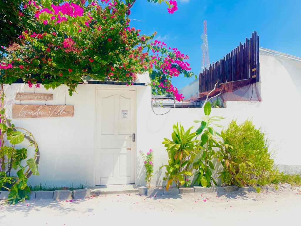 a white house with pink flowers on it at Thulusdhoo Garden Villa in Thulusdhoo
