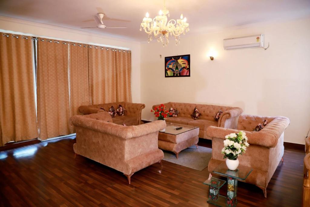 a living room with couches and a chandelier at Divine India Service Apartment 2Bhk, 2A Saket in New Delhi