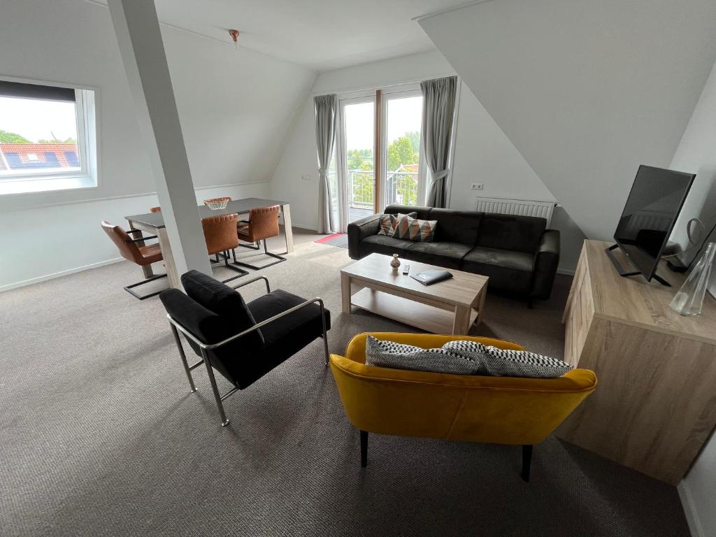 a living room with a couch and a table at Penthouse DeLuxe in Oostkapelle