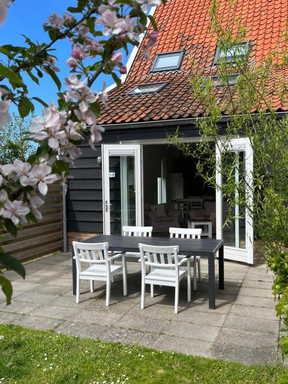 a picnic table and chairs in front of a house at Vakantiehuizen 't Centrum in Oostkapelle