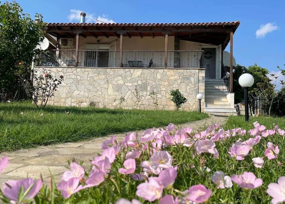 une maison avec des fleurs roses devant elle dans l'établissement Carefree Dreams : Cottage in Flogita Chalkidiki, à Flogita
