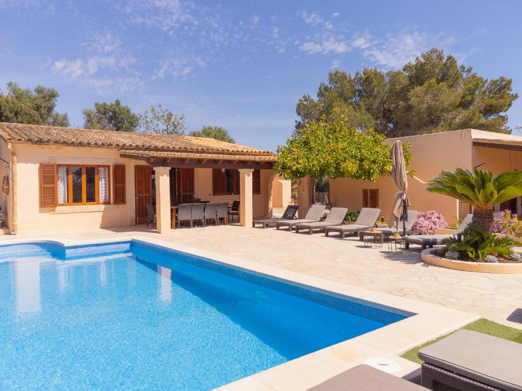 a swimming pool in front of a house at Finca Torrent Des Jai in Cala Mondrago