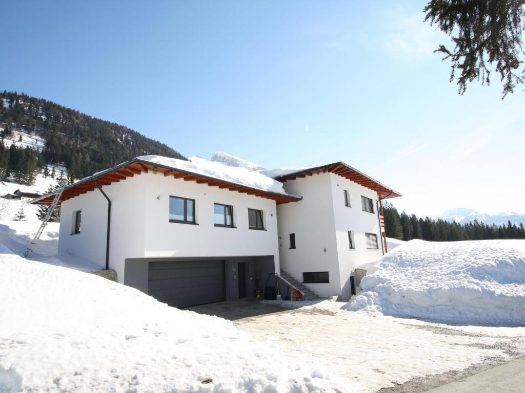 una casa blanca con nieve en el suelo en Cosy Apartment in Annaberg with Private Garden, en Annaberg im Lammertal