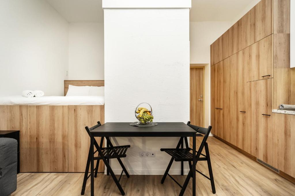 uma sala de jantar com uma mesa preta e duas cadeiras em Air Apartment 318 em Vilnius