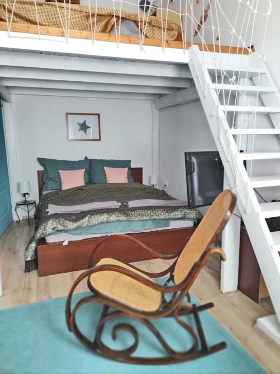 ein Schlafzimmer mit einem Bett, einer Leiter und einem Stuhl in der Unterkunft Old Buda Family Home in Budapest