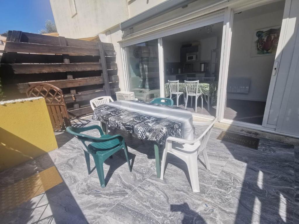 une table et des chaises assises sur une terrasse dans l'établissement 5041 Tennis Village 307, au Cap d'Agde