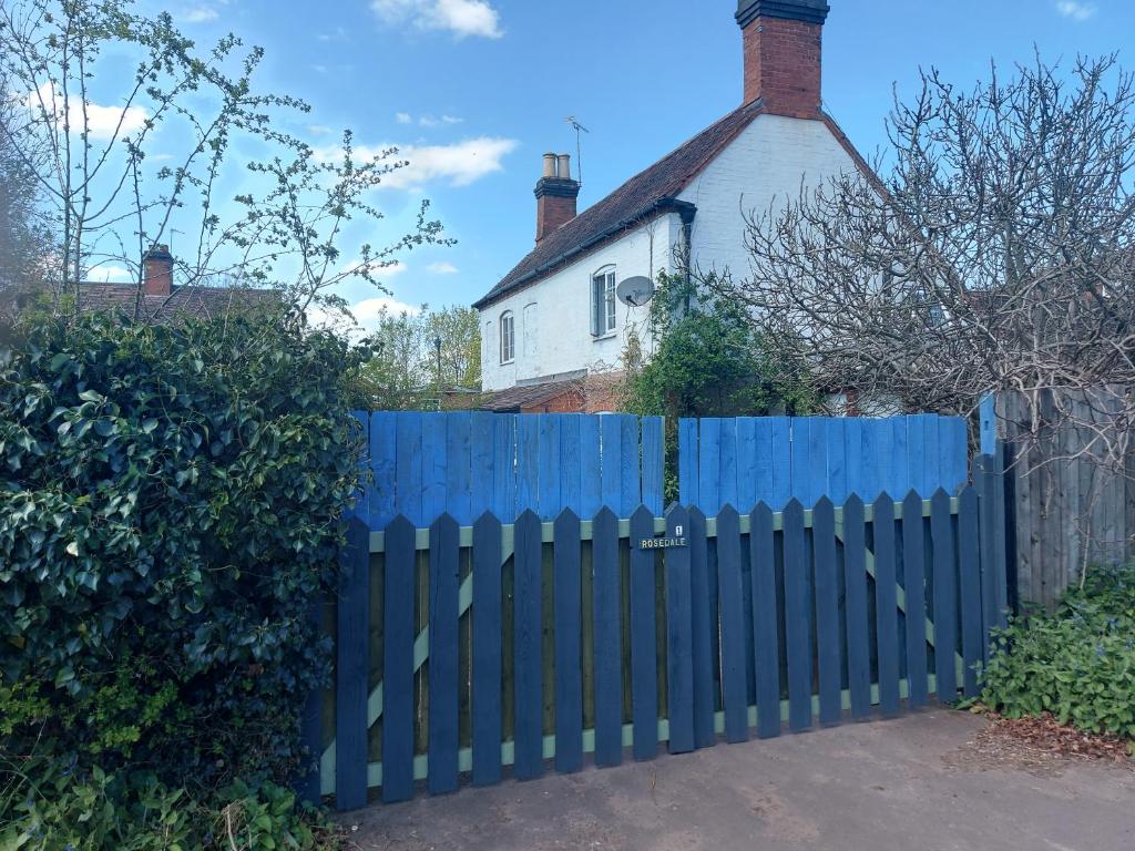 ein blauer Zaun vor einem Haus in der Unterkunft rosedale cottage in Walsgrave on Sowe