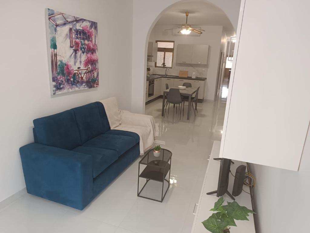 sala de estar con sofá azul y cocina en Seagull Flats, en Marsalforn