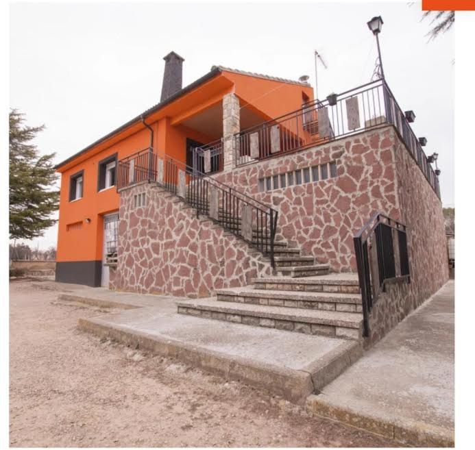 een oranje gebouw met een trap ervoor bij Casa naranja in Teruel