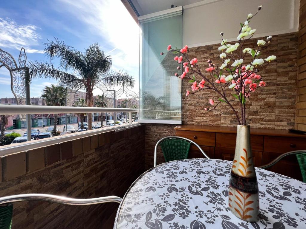 a table with a vase of flowers on a balcony at Hermoso y Acogedor bien situado in Oropesa del Mar