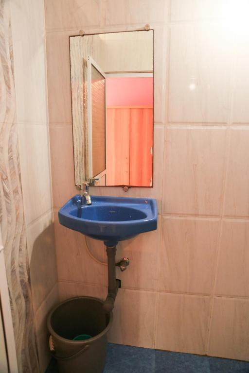 a bathroom with a blue sink and a mirror at Dreamcatcher House & Hostel at Arambol Beach in Arambol
