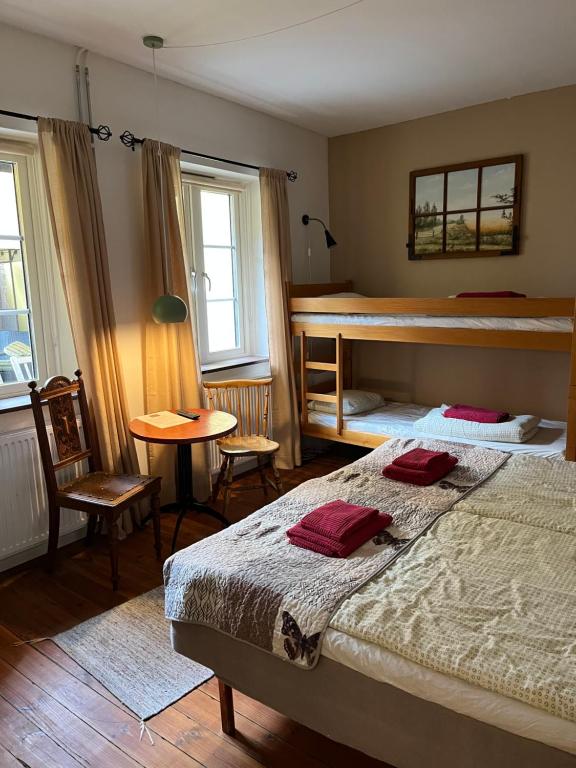 Sveriges minsta Hotell! Hôtel Gruyère في لاندسكرونا: غرفة نوم مع سرير بطابقين وطاولة وكراسي