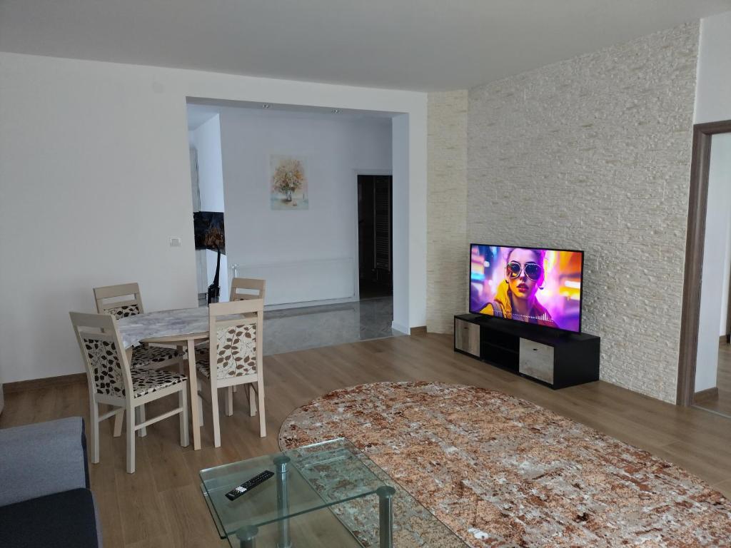 a living room with a television and a dining room table at TSG Apartaments in Valea lui Mihai