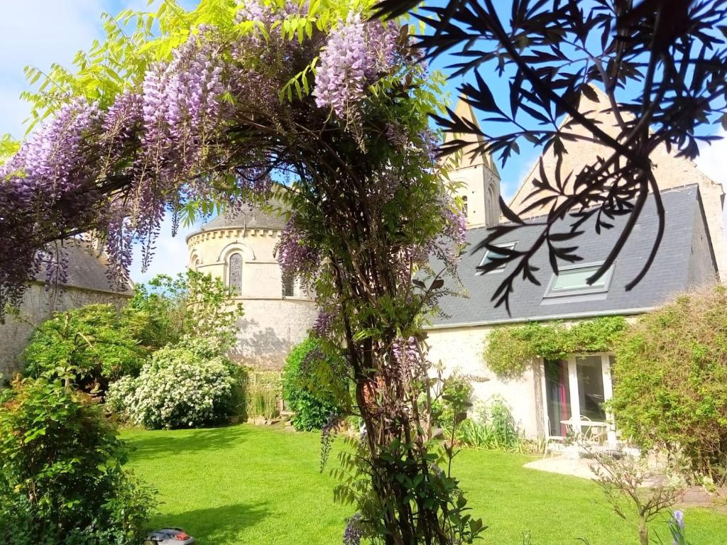 einen Kranz mit lila Blumen auf einem Baum im Hof in der Unterkunft Atelier aux Dimes in Le Manoir