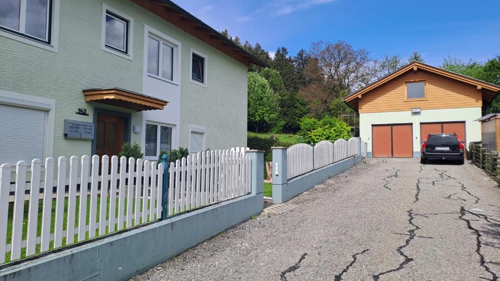 a white picket fence in front of a house at Come a casa 