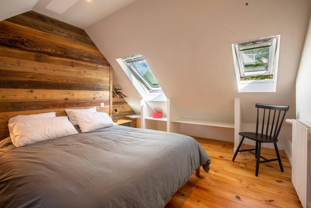 a bedroom with a large bed and two windows at Gîte d&#39;AURE. Classé en meublé 4 étoiles. 