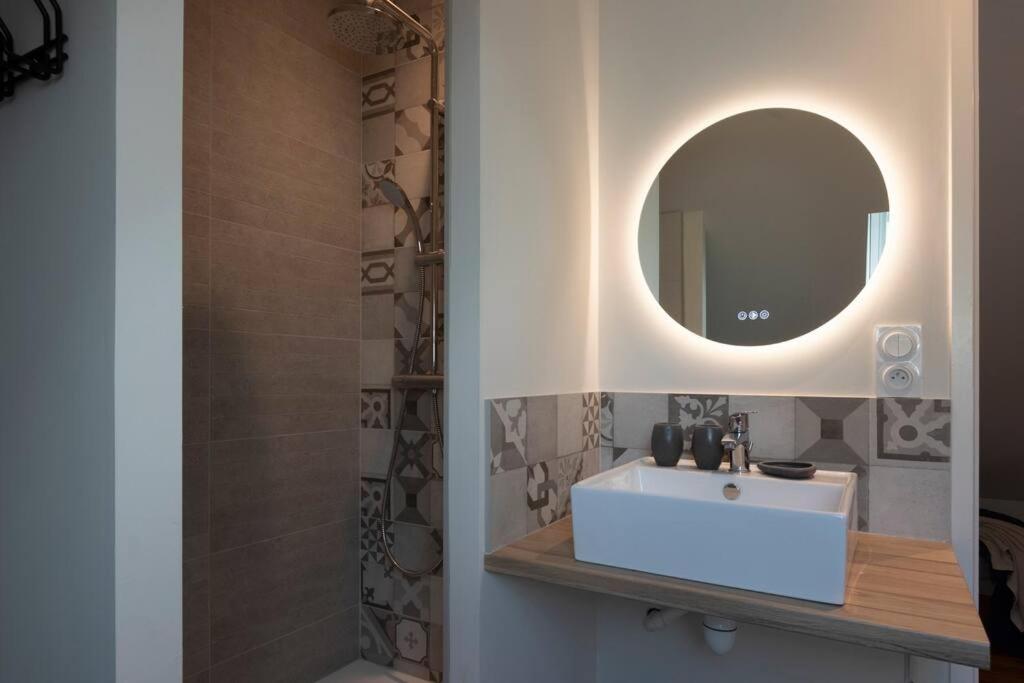 a bathroom with a white sink and a mirror at Gîte d&#39;AURE. Classé en meublé 4 étoiles. 