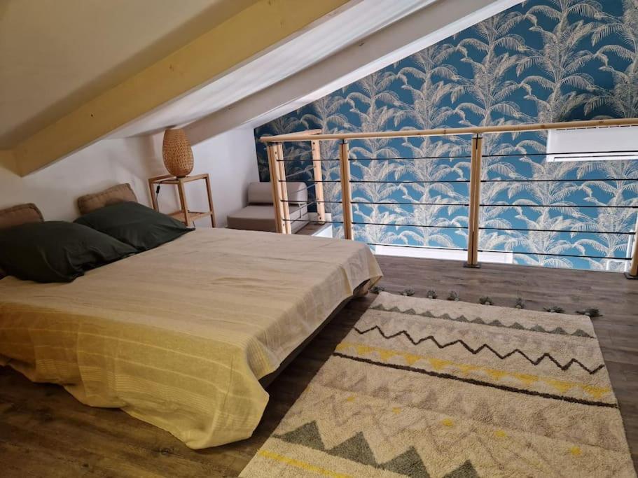 - une chambre avec un lit et un mur bleu et blanc dans l'établissement La Maison de Léonie sur Vias, à Vias