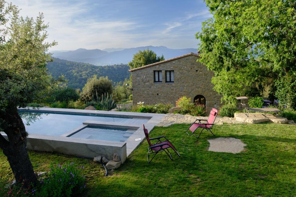 un patio con piscina y 2 sillas y una casa en Arc de can Puig Luxury Holiday Home in catalonia, en Sant Ferriol