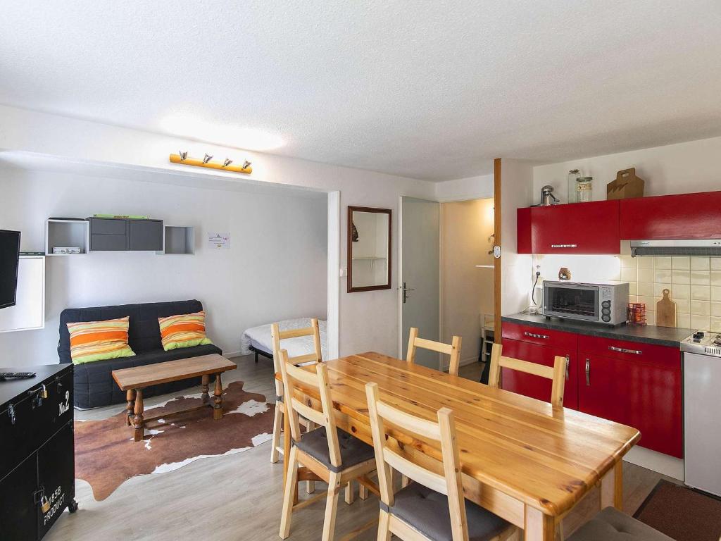 a kitchen and living room with a wooden table and chairs at Appartement Cauterets, 2 pièces, 5 personnes - FR-1-401-229 in Cauterets