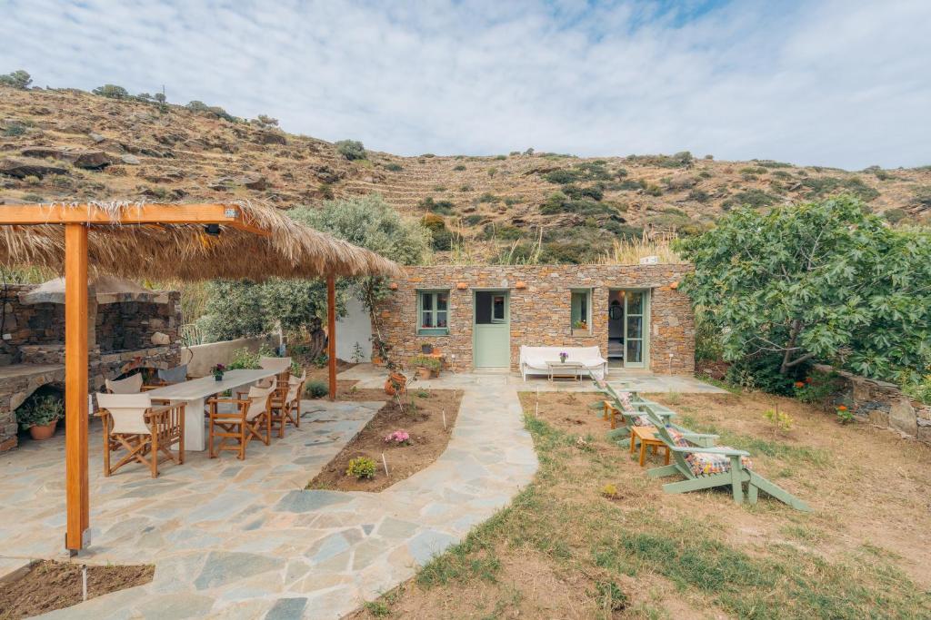 a patio with tables and chairs and a building at Houses at Chrisopigi Sifnos in Chrisopigi