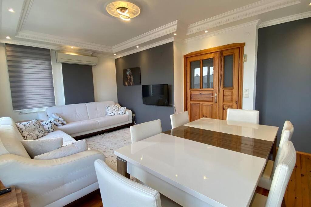 a living room with a white table and white chairs at Denize 100 mt 2+1 merkezde daire in Alanya