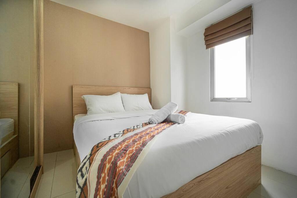 een slaapkamer met een groot wit bed en een raam bij Premium 2BR @ Bassura City East Jakarta in Jakarta