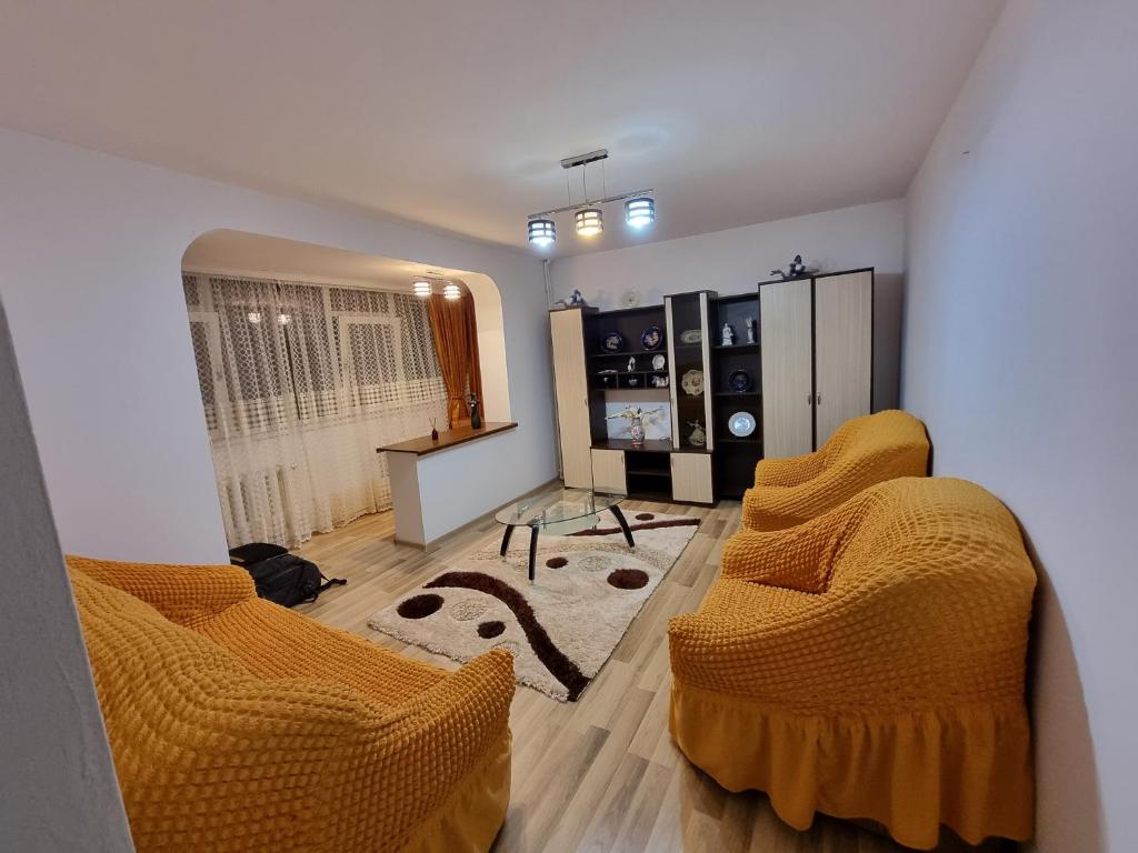 a living room with orange cushioned chairs in a room at Vali Apart in Mangalia