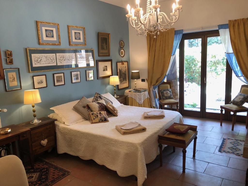 una camera con un grande letto e un lampadario a braccio di La passeggiata a Spoleto