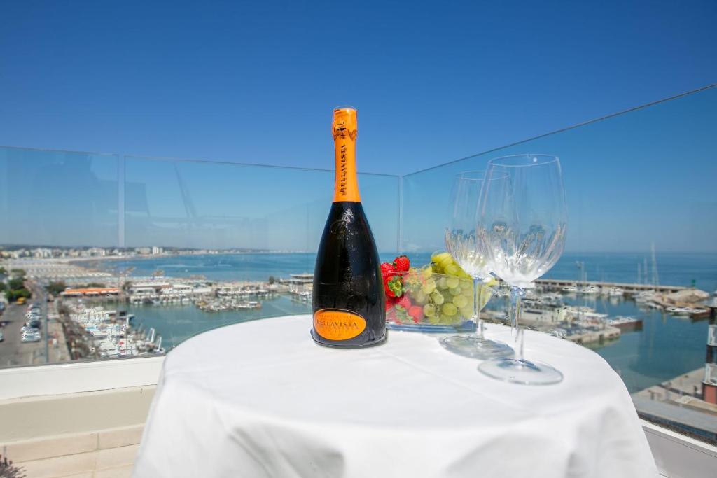 una botella de vino sentada en una mesa con copas de vino en Hotel Europa, en Gabicce Mare