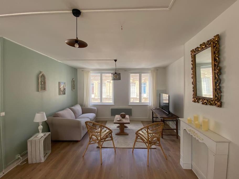 sala de estar con sofá, sillas y espejo en Suites Carnot, Venise Normande., en Pont-Audemer