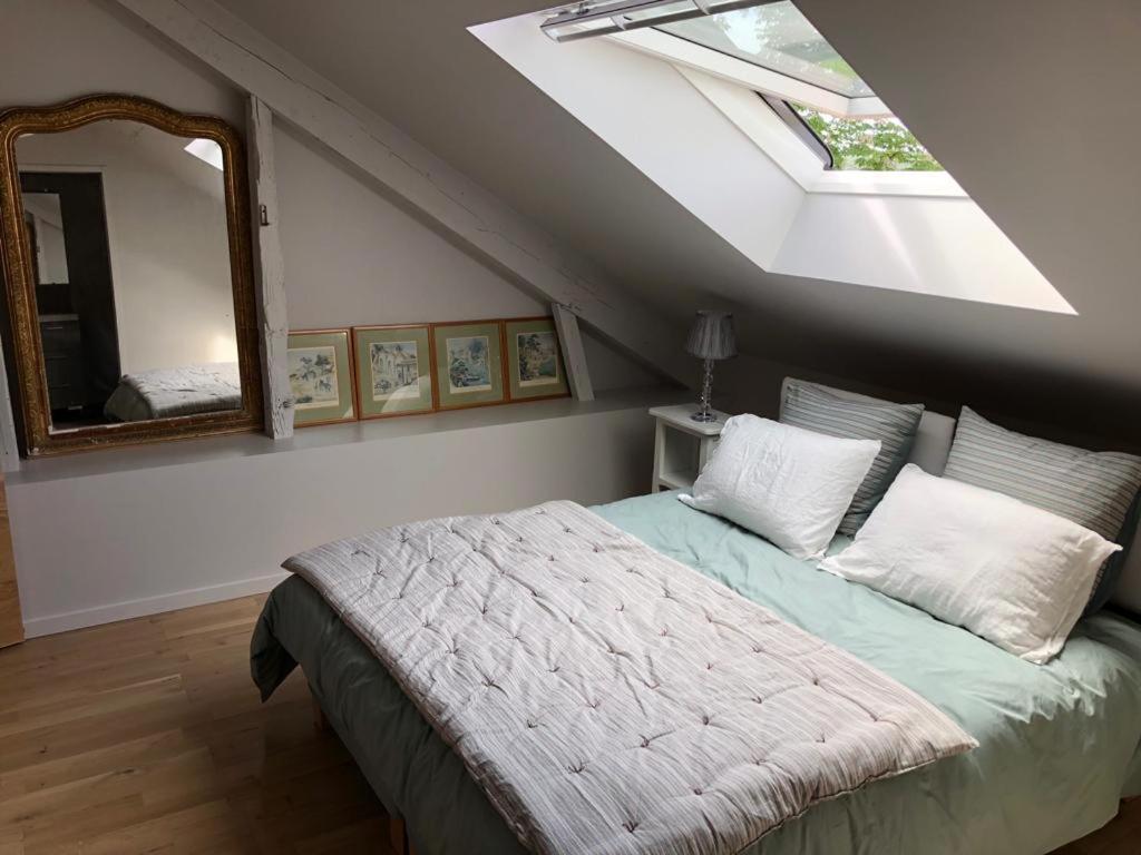 ein Schlafzimmer mit einem Bett und einem großen Spiegel in der Unterkunft Maison Puchouaou Chambres d'Hôtes sur le chemin de Saint jacques de Compostelle in Montesquiou
