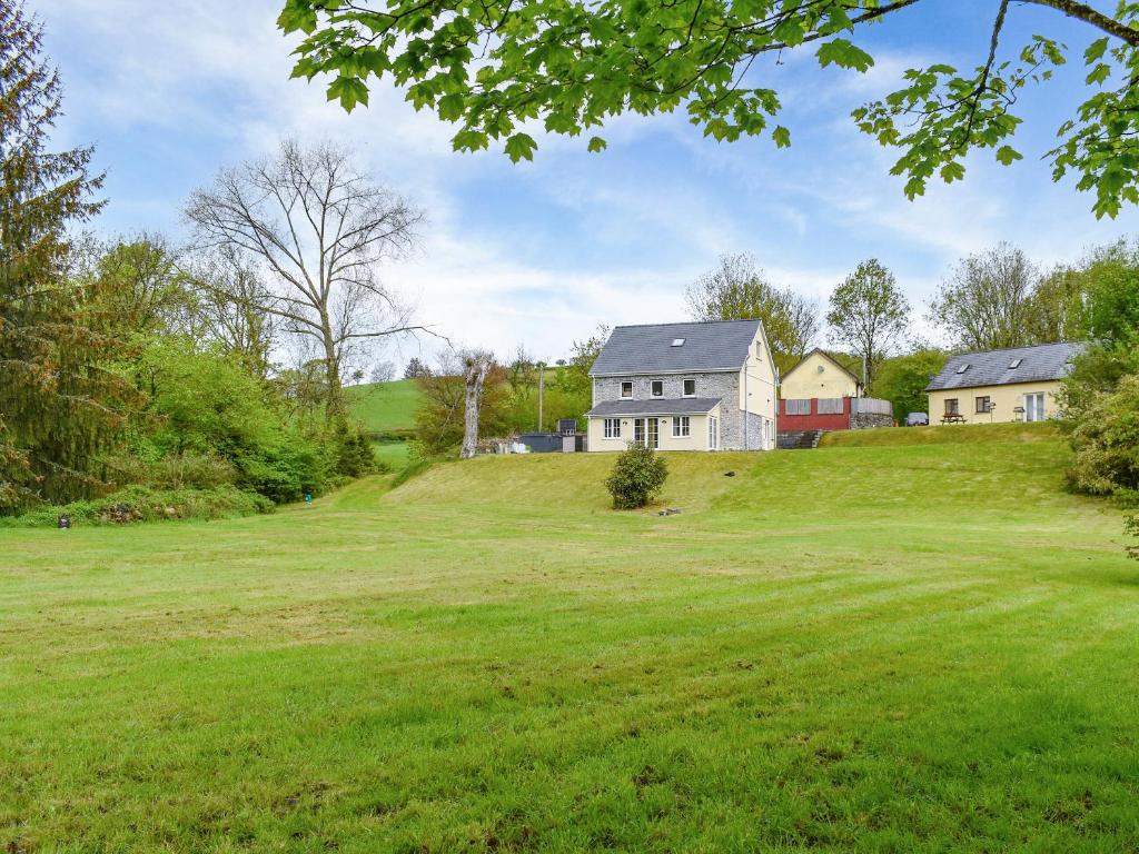 a house on a hill with a large green field at Goitre Farmhouse in Llanwrda