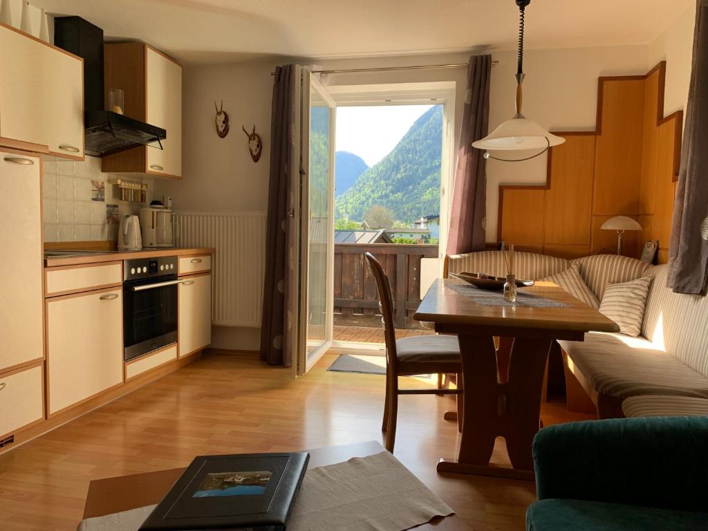 eine Küche und ein Wohnzimmer mit einem Tisch und Aussicht in der Unterkunft Haus Cäcilia in Sankt Martin bei Lofer