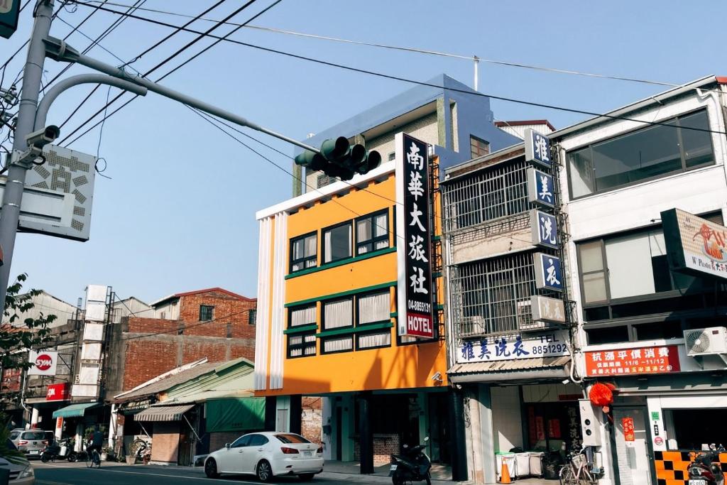 un bâtiment situé sur le côté d'une rue de la ville dans l'établissement 鴉埠客棧x南華大旅社, 