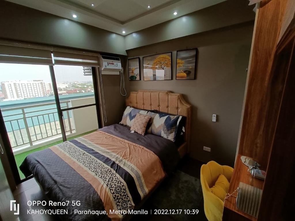 Schlafzimmer mit einem Bett und einem Fenster mit Aussicht in der Unterkunft 2 BR luxury type Condo Unit in Manila