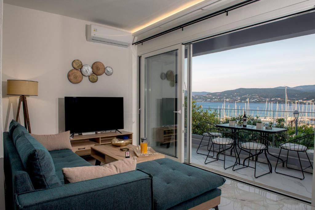 sala de estar con sofá, TV y balcón en Nicolas Exclusive Apartment, en Agios Nikolaos