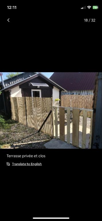 a wooden fence with a gate in front of a house at Petite maison chaleureuse des boucles de la Seine in Le Mesnil-sous-Jumièges