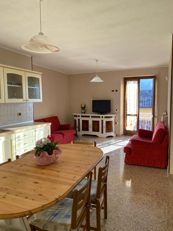 una cucina e un soggiorno con tavolo in legno di Appartamento Angolo Fiorito a Provaglio Val Sabbia