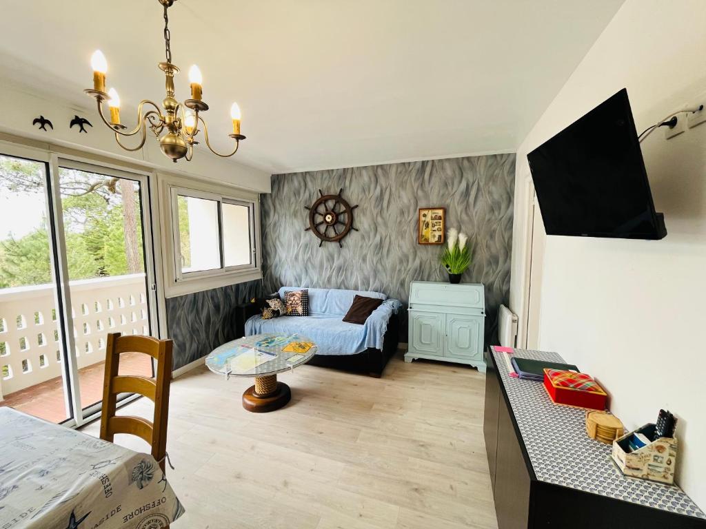 un salon avec un lit et une table dans l'établissement Appartement pinède et océan, à Saint-Jean-de-Monts