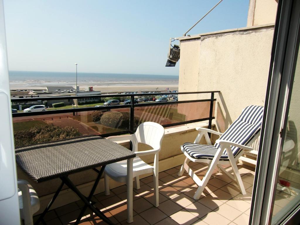 un balcon avec une table et des chaises et une vue sur la plage dans l'établissement Le Touquet magnifique appartement 3 chambres vue sur mer, à Le Touquet-Paris-Plage