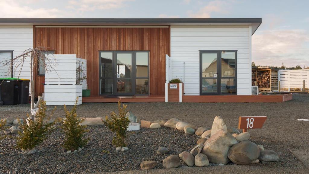 a house with windows and rocks in front of it at Entire Unit - 18 Rodman - newly furnished in Lake Tekapo