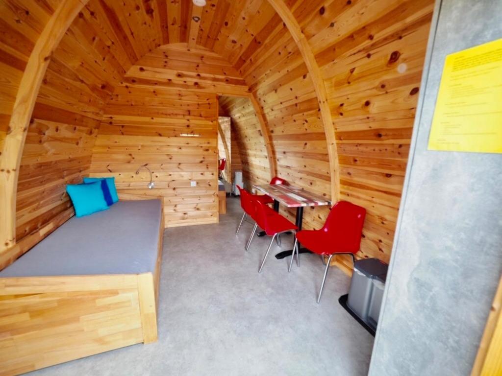 Habitación con cama y sillas en una cabaña en Holzhütte I21 groß en Reichenau