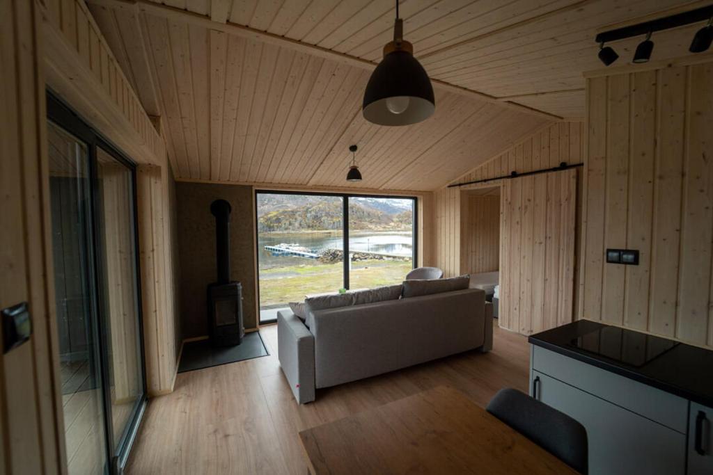 a living room with a couch and a large window at Skårungen - Hotel, Cabins and Camping in Kabelvåg