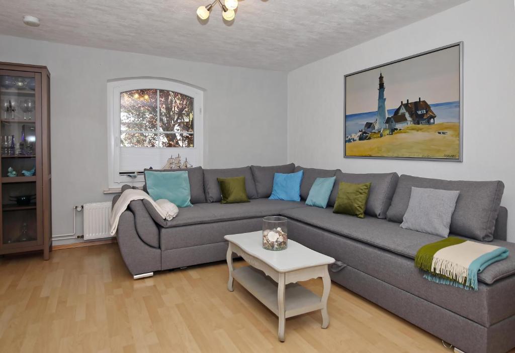 - un salon avec un canapé gris et une table dans l'établissement Ferienhaus Hinter-Bollhagen, à Wittenbeck