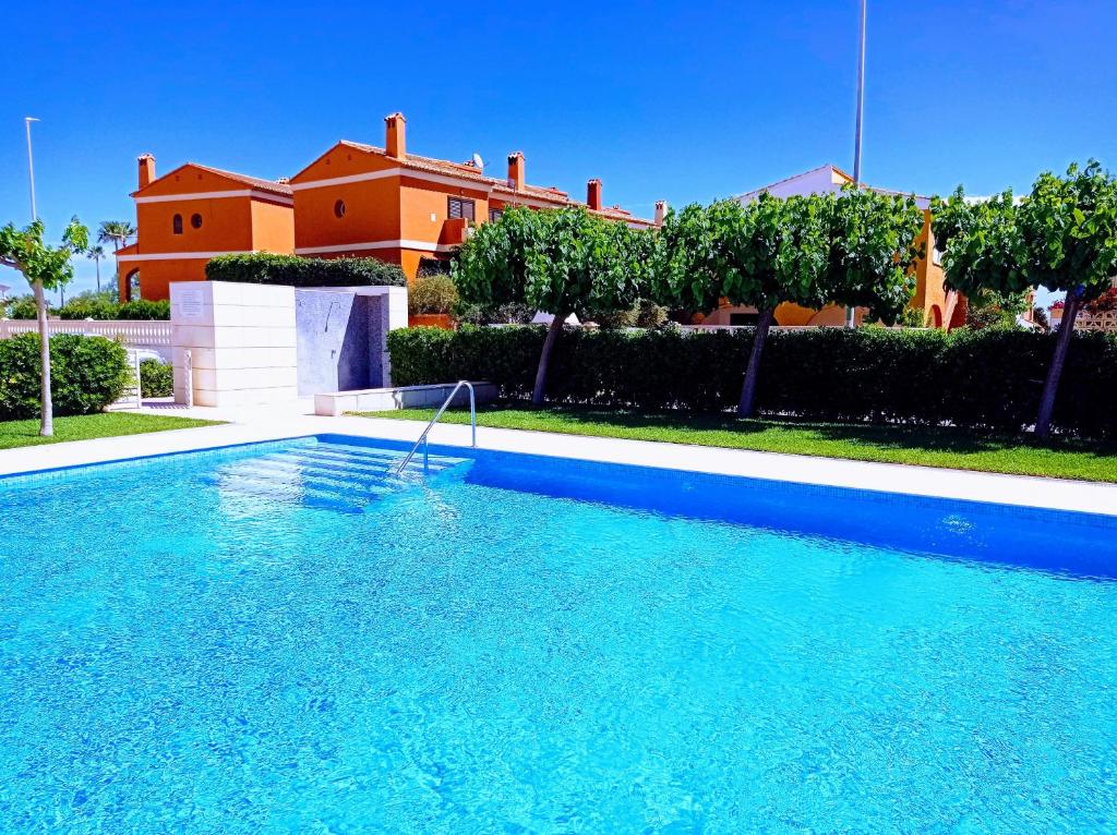 a large blue swimming pool in front of a house at Bonsol Solo Familias Serviplaya in Playa de Xeraco