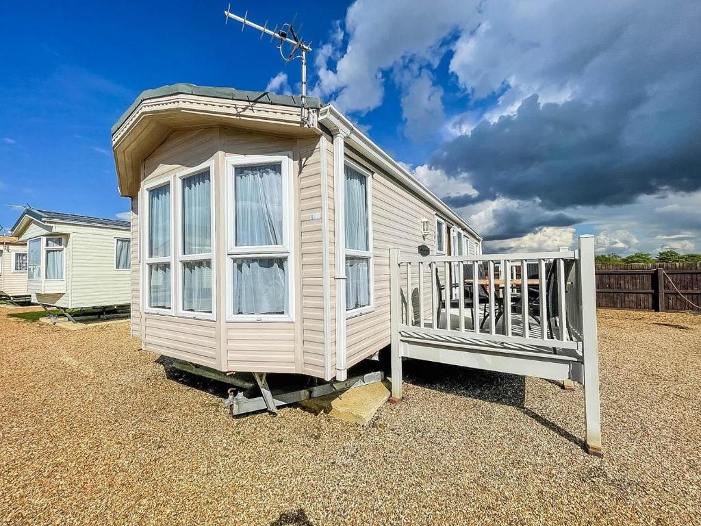 a tiny house sitting on the gravel in a yard at 6 Berth Caravan Nearby Hunstanton Beach Front In Norfolk Ref 13019l in Hunstanton