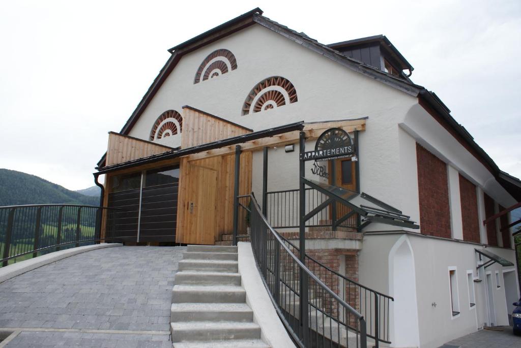 a building with a staircase leading up to it at Premium Appartements Di Bora in Sankt Michael im Lungau